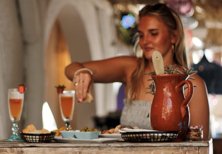 Gast schenkt sangria uit een kan bij Beachcafé Tulp