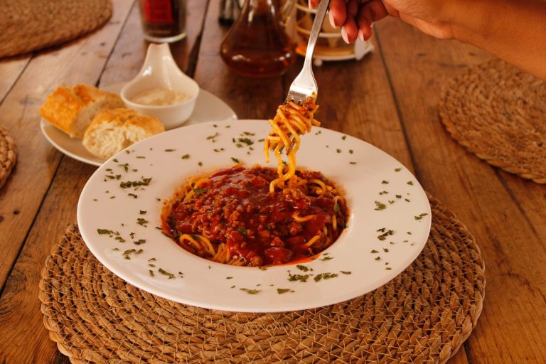 Pasta met tomatensaus wordt opgeschept bij Beachcafé Tulp